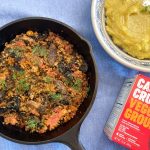 plantbased paprikash in a skillet with a bowl of polenta and a box of Big Mountain Food cauli crumbles