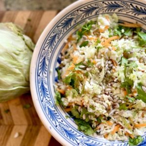 A bowl of sunflower slaw made with cabbage, sunflower seeds and caraway seeds.