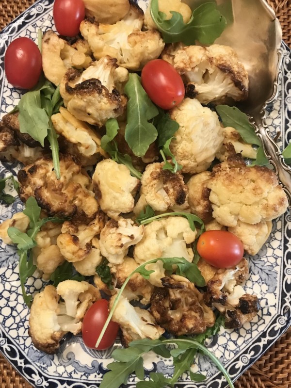 A plate of roasted cauliflower, arugula and tomatoes for pantescan pasta.