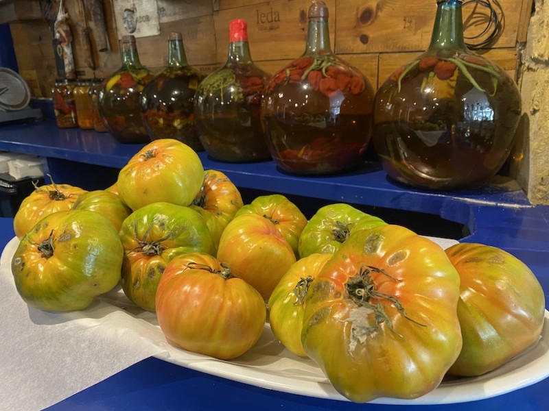 Heirloom tomatoes on a platter with oil in the background.